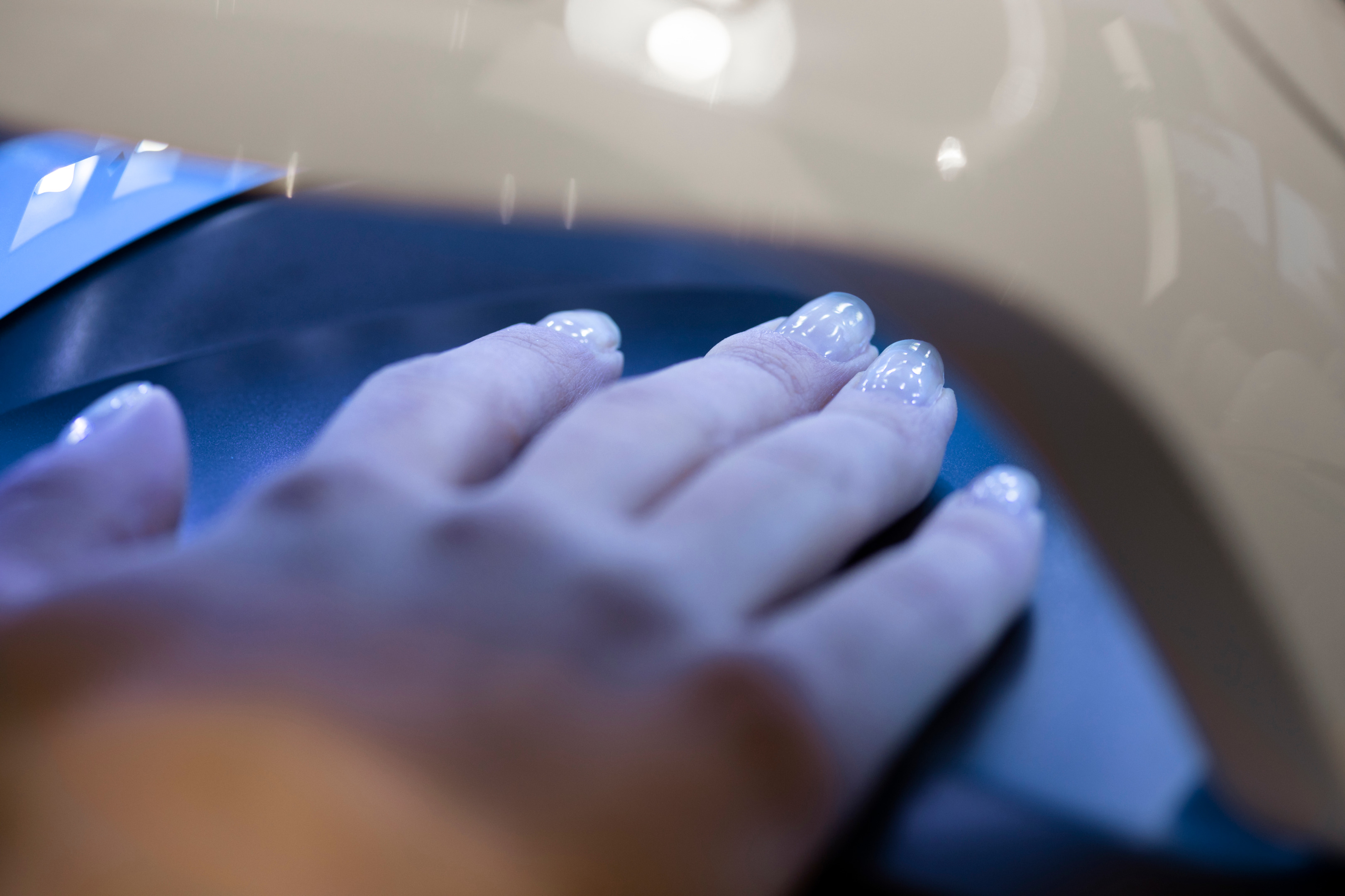 A person's fingers placed under a UV lamp